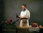 Butcher with meat from pig, sharpening knife