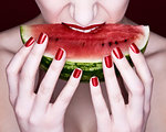 Woman biting slice of watermelon