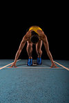 Young female athlete on starting blocks