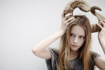 Portrait of girl holding horns on her head