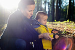 Mother and young toddler looking at tree stump