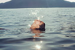 Young woman floating on back in Lake Attesee, Austria