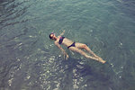 Young woman floating on her back in lake