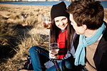 Couple celebrating with white wine at coast, Bournemouth, Dorset, UK