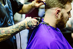 Close up of barber clipping clients hair