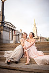 Portrait of two female models posing on steps, Trafalgar Square, London, UK