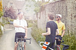 Cyclists stopping by stone wall, Cotswolds, UK