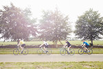 Cyclists riding on leafy countryside road, Cotswolds, UK