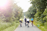 Cyclists riding on leafy countryside road, Cotswolds, UK