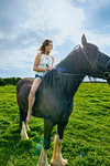 Portrait of young woman riding horse in field