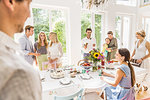 Family chatting around party table  in dining room