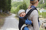 Mother and baby exploring woodland, mother carrying baby on back