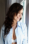 Brunette woman sitting by window