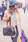 Stylish young female shopper looking over her shoulder, London, UK