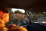 Woman travelling in vehicle, Nxai Pan National Park at sunset, Kalahari Desert, Africa