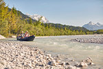 Family using paddles to steer dinghy on water, Wallgau, Bavaria, germany