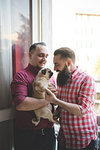 Gay couple with dog by window