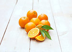 Whole and half Florida oranges on whitewashed wooden table