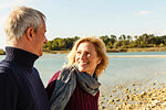Mature couple beside lake, smiling