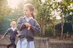 Elementary schoolgirl eating cracker in playground