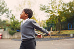 Elementary schoolboy running in playground