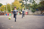 Elementary schoolboy and girl running in playground