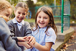 Elementary schoolgirls playing hand game in school playground