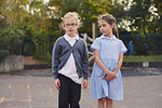Portrait of two elementary schoolgirls standing in school playground