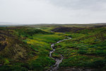 High angle view of river winding through lush green fields, Iceland