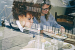 Cafe window view of two women eating lunch