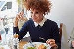 Young woman having lunch with friends in cafe