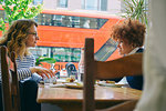 Two women friends eating lunch and chatting in cafe