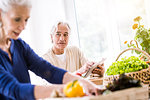 Senior couple using digital tablet and preparing food at kitchen counter