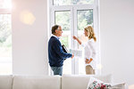 Couple in front of french doors discussing paperwork