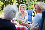 Three women sitting in garden, enjoying drink