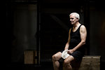 Senior man sitting resting in dark crossfit gym