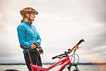 Mature female mountain biker looking out from lakeside