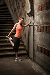 Woman stretching on city steps