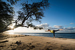 Woman practicing yoga on beach