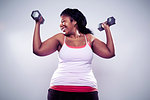 Mature woman using hand weights, smiling