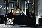 Woman lifting a large tyre in gym