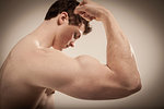 Side view of body builder flexing right arm