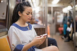Mid adult women using mobile phone on subway, New York
