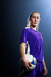 Studio shot of young female soccer player holding ball