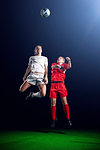 Two female soccer players heading ball