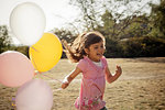 Girl running with balloons