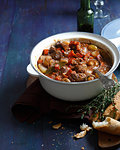 Beef daube in casserole dish with baguette