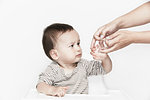 Hands applying plaster to baby's finger