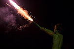 Boy holding rocket at night on independence day, Destin, Florida, USA