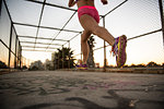 Legs of female jogger running on walkway